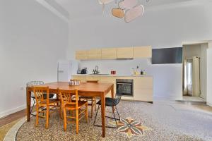 - une cuisine avec une table à manger en bois et des chaises dans l'établissement NOCNOC - Le Terrazzo - Petite piscine et jardin en ville, à Montpellier