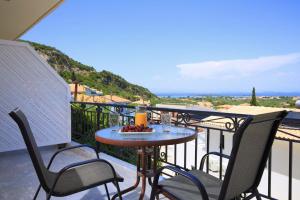 a table and chairs on a balcony with a view at VILLA CORINA in Apolpaina