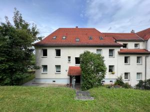 a large white building with a red roof at EDLER WOHNRAUM Modernes Vorstadtstudio mit Kaffeevollautomat, Garten & Netflix in Zwickau