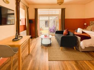 een slaapkamer met een bed, een bank en een tafel bij Timbertop Suites - Adults Only in Weston-super-Mare