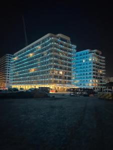 een groot gebouw met blauwe ramen 's nachts bij SUNDREAM by the beach in Mamaia