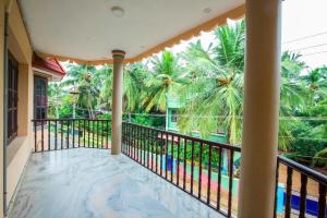 a balcony of a house with palm trees at Phoenix Holiday Home in Kanyakumari
