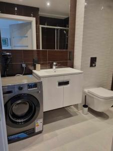 a bathroom with a washing machine and a toilet at Apartamenty hotelowe w Jarosławcu in Jarosławiec +29 photos