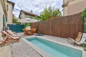 a backyard with a swimming pool and a fence at NOCNOC Le Joïa - Petite piscine et jardin en ville in Montpellier
