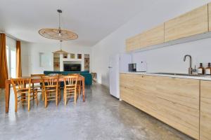 a kitchen with a table and chairs in a kitchen at NOCNOC Le Joïa - Petite piscine et jardin en ville in Montpellier