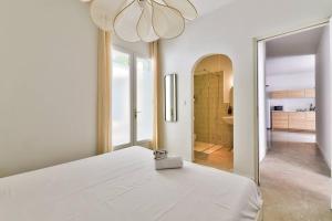 a white bedroom with a bed and a mirror at NOCNOC Le Joïa - Petite piscine et jardin en ville in Montpellier