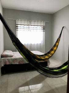 - un hamac dans une chambre avec un lit et une fenêtre dans l'établissement Casa Vitória, à Camocim