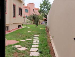 einen Garten mit Felsen im Gras neben einem Gebäude in der Unterkunft Garden Beet in Sidi Rahal