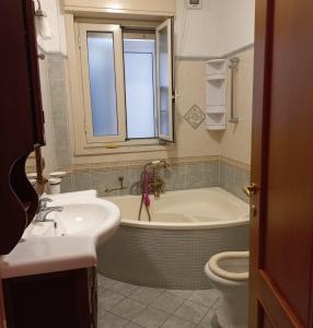 a bathroom with a tub and a sink and a toilet at Alba Marina e Tramonti Etnei in Riposto