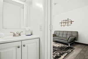 a bathroom with a sink and a couch in a room at Sunset Inn-South Miami in South Miami