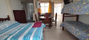 1 dormitorio con 2 camas, mesa y mesa en Delta House en Salta