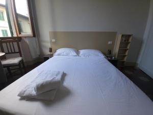 a large white bed with two towels on it at Homely studio flat 10 minutes from the city centre in Florence