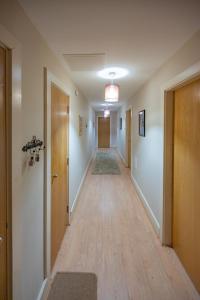 an empty hallway of an apartment with wooden floors and doors at Cloister View in Fort Augustus