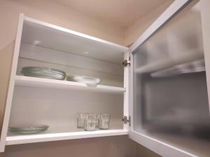a cupboard with plates and glasses in it at Apart26 C425 Dpto hermoso en Tucumán in San Miguel de Tucumán +43 photos