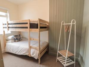 a bedroom with a bunk bed with a ladder at Gudhjem in Seahouses