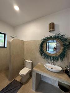 uma casa de banho com um lavatório, um WC e um espelho. em Maracuja villa Zanzibar em Bwejuu