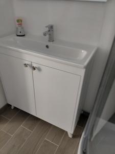 y baño con lavabo blanco y ducha. en Beau studio indépendant à15mn de la plage, proche de toute commodité en Béziers