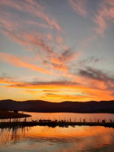 einen Sonnenuntergang über einem Wasserkörper mit dem Himmel in der Unterkunft Sítio à beira da represa in Nazaré Paulista