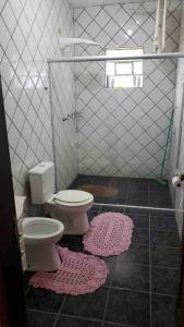 ein Badezimmer mit WC und zwei Matten auf dem Boden in der Unterkunft Sítio à beira da represa in Nazaré Paulista + 27 Fotos