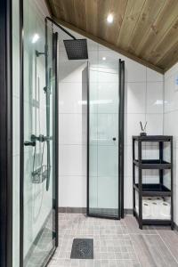 uma porta de duche em vidro numa casa de banho com uma prateleira em Hodlekvevegen 307 em Sogndal