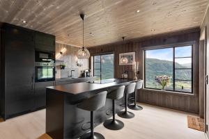 a kitchen with a large island with bar stools at Hodlekvevegen 307 in Sogndal