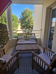 a porch with two benches and a table on a balcony at Beau 3 pièces à Nice - terrasses et piscine in Nice
