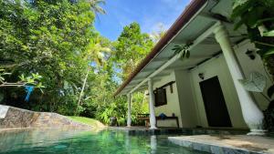 a house with a swimming pool in front of it at Medusa Bungalow - Galle in Galle