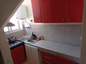 - une cuisine avec des placards rouges et un évier dans l'établissement maison Halima, à Ifrane