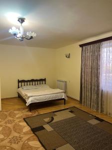 a bedroom with a bed and a window with a rug at Hotel KA-EL in Musalerr