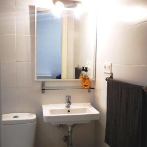 een badkamer met een wastafel, een toilet en een spiegel bij Panoche Apartamento a 750m de la Catedral A/A in Murcia