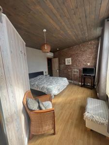 een slaapkamer met een bed en een bank in een kamer bij Dolce far niente in Brugge