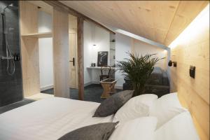 a bedroom with a large bed and a bathroom at Miroir d'Argentine in Gryon