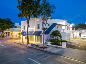 um parque de estacionamento em frente a um edifício branco em Sunset Inn-South Miami em South Miami