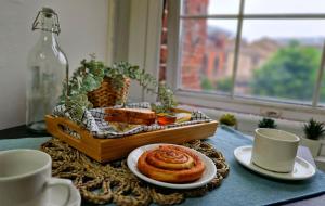 a table with a tray of pastries and a basket of bread at Private room near Tower of London in London