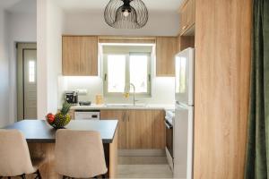a kitchen with a table with chairs and a refrigerator at Alonakia Home Suites in Filiatra