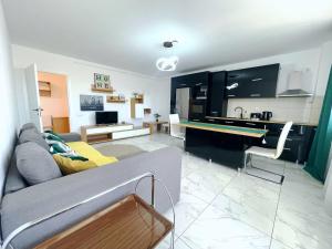 a living room with a couch and a kitchen at YamaLux Apartments - Ploiesti 33 in Cluj-Napoca +6 photos