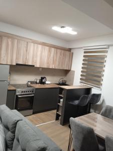 una cucina con armadi in legno, tavolo e divano di Eva apartment a Štip