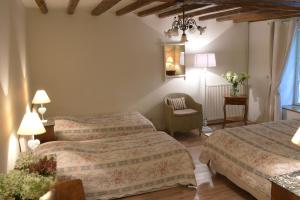 a hotel room with two beds and a chair at Domaine de l'Ermitage in Berry-Bouy