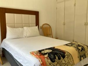 a bedroom with a large white bed with a wooden headboard at Vista al mar y alberca privada en Sector Bahía in San Carlos