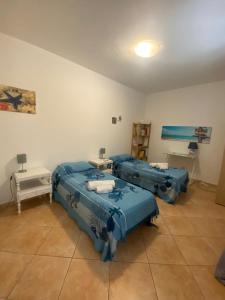 een kamer met drie blauwe bedden en een tafel bij A casa di Loretta in Terrasini