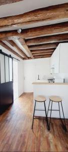 a kitchen with two stools and a counter in a room at Attrayant studio tout équipé en Bord de Marne - Proche Disney in La Ferté-sous-Jouarre +7 photos