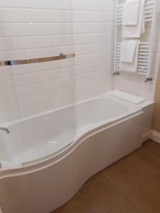 eine weiße Badewanne im Bad mit weißen Handtüchern in der Unterkunft Snooze Apartments in Newcastle