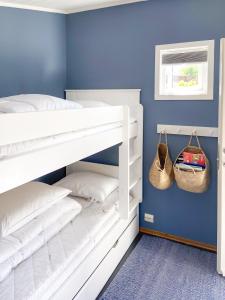 - une chambre avec des lits superposés blancs et un mur bleu dans l'établissement Magical place with the South Coast Norway!, à Kristiansand