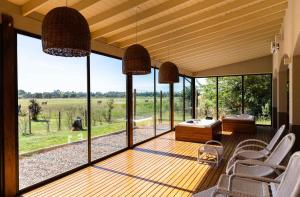 Habitación con una gran ventana de cristal con mesa y sillas. en Wyndham Garden Luján en Luján