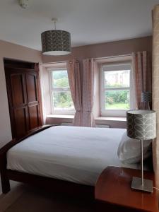 - une chambre avec un grand lit et 2 fenêtres dans l'établissement Snooze Apartments, à Newcastle