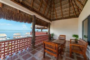 a room with a table and chairs and a view of the ocean at Posada El Perico Marinero in Río Lagartos