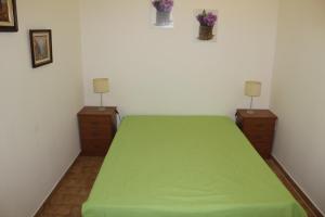 ポルティマンにあるApartamentoSolPraia - Pátio da Rochaのベッドルーム1室(緑のベッド1台、ドレッサー2台付)