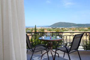 a table and chairs on a balcony with a view at VILLA CORINA in Apolpaina
