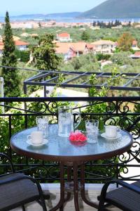 a table on a balcony with cups and glasses on it at VILLA CORINA in Apolpaina
