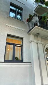 Cette maison blanche dispose d'une fenêtre et d'un balcon. dans l'établissement Mini Wind Apartment, à Liepāja